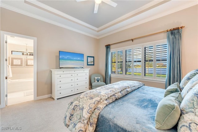 carpeted bedroom with ceiling fan with notable chandelier, a raised ceiling, crown molding, and connected bathroom