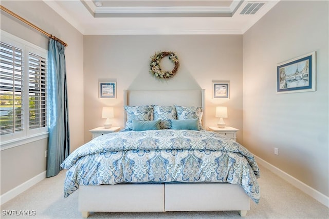 carpeted bedroom featuring ornamental molding and a tray ceiling