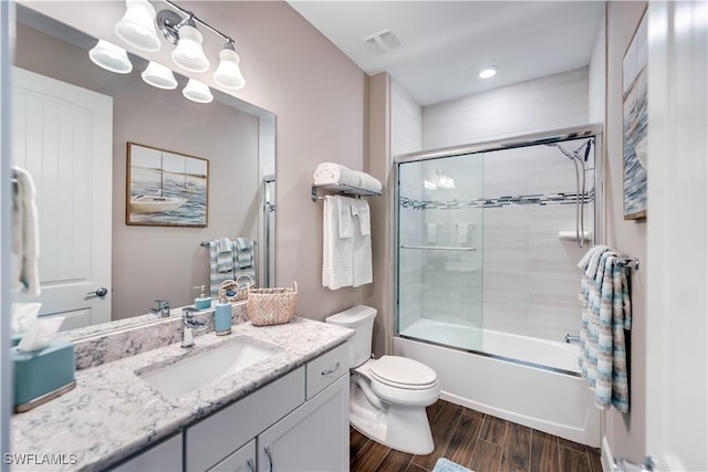 full bathroom with toilet, vanity, bath / shower combo with glass door, and hardwood / wood-style flooring