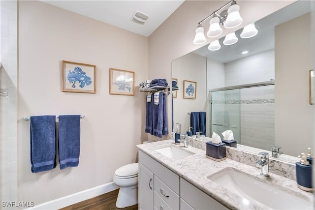 bathroom featuring wood-type flooring, vanity, toilet, and an enclosed shower