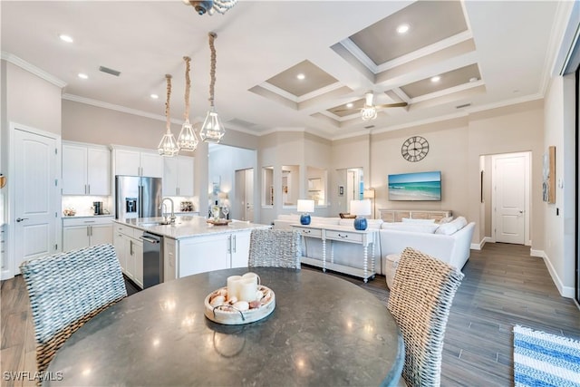 dining space with crown molding, sink, dark wood-type flooring, and coffered ceiling