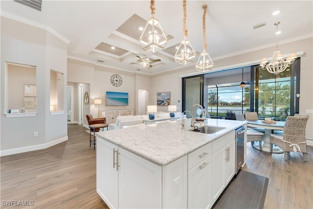 kitchen with light wood-type flooring, coffered ceiling, sink, a center island with sink, and white cabinets