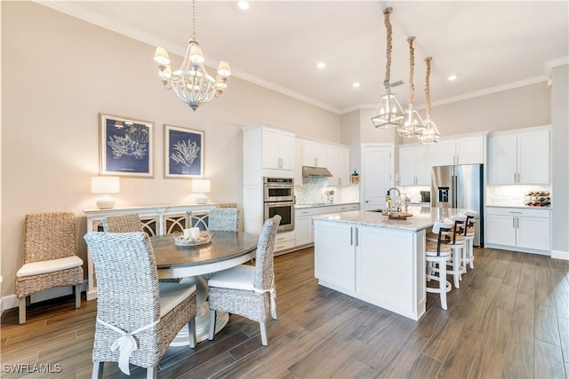 kitchen with white cabinets, an island with sink, and dark wood-type flooring