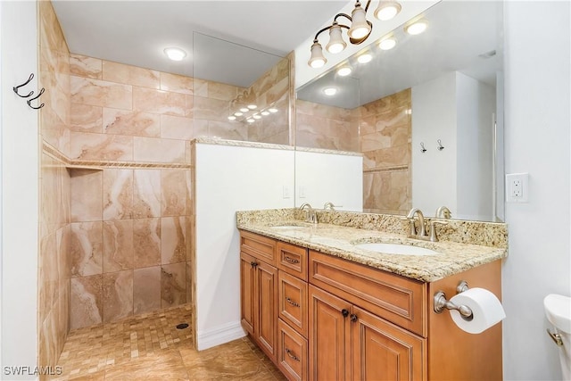 bathroom featuring vanity, toilet, and tiled shower