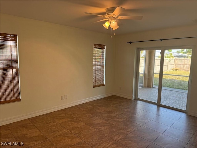 tiled spare room with ceiling fan