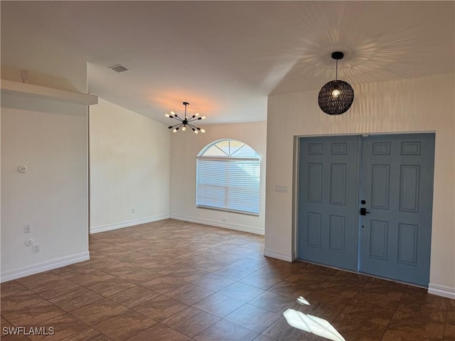 tiled entryway featuring an inviting chandelier