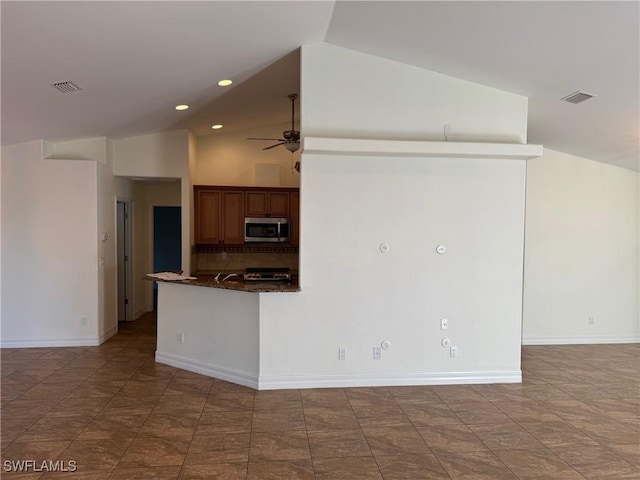 kitchen featuring kitchen peninsula, tasteful backsplash, dark stone counters, stainless steel appliances, and ceiling fan