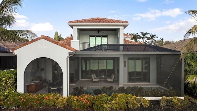 back of property with area for grilling, ceiling fan, and a balcony