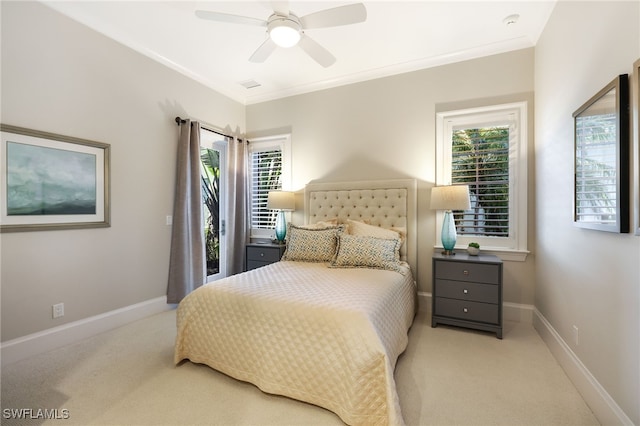 carpeted bedroom with ceiling fan, ornamental molding, and multiple windows