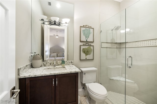 bathroom with ceiling fan, a shower with door, vanity, and toilet