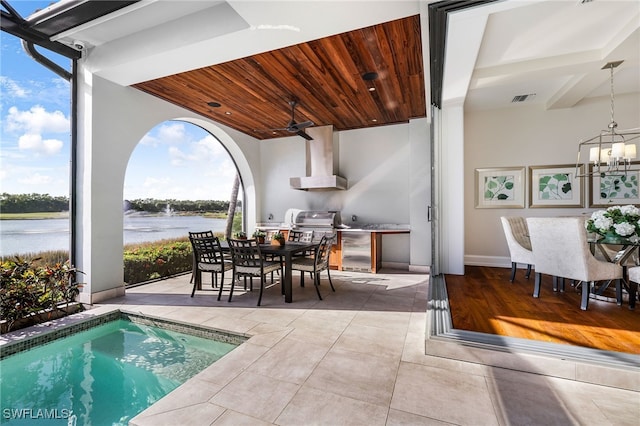 interior space featuring grilling area, ceiling fan, and a water view