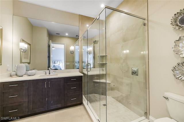 bathroom with tile patterned floors, vanity, an enclosed shower, and toilet