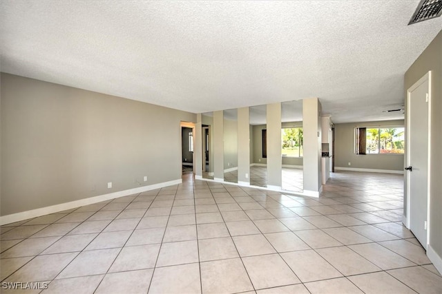 tiled spare room with a textured ceiling