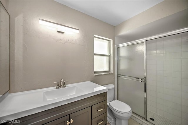 bathroom featuring vanity, toilet, and a shower with door