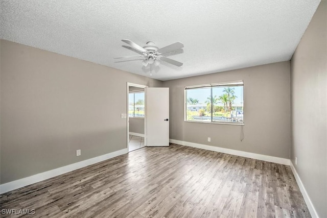 spare room featuring hardwood / wood-style flooring, ceiling fan, and a textured ceiling