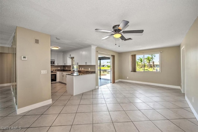 kitchen with a textured ceiling, stainless steel appliances, ceiling fan, white cabinets, and light tile patterned flooring