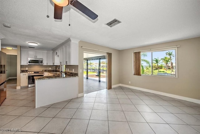 kitchen featuring a wealth of natural light, white cabinetry, kitchen peninsula, and appliances with stainless steel finishes