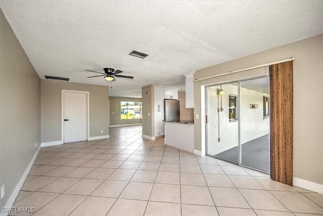 tiled empty room featuring a textured ceiling and ceiling fan