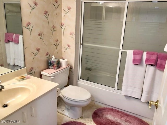 full bathroom with shower / bath combination with glass door, tile patterned floors, vanity, and toilet