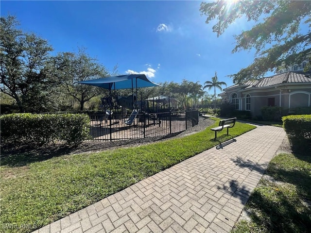 community jungle gym with a lawn and fence