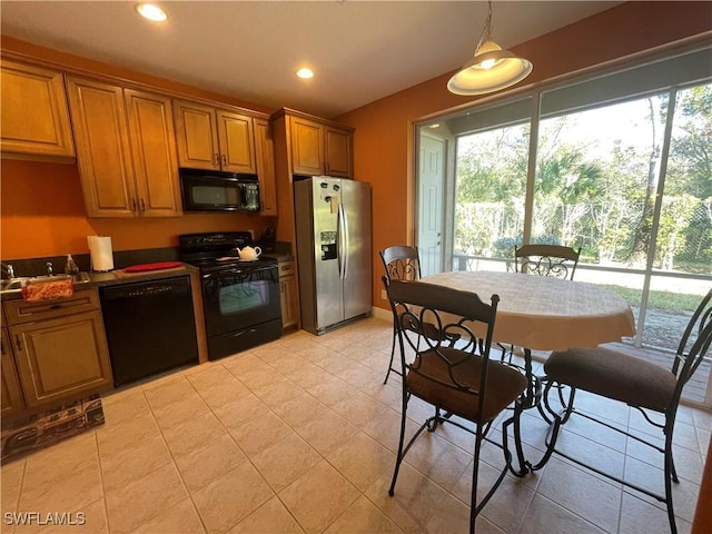 kitchen featuring light tile patterned floors, hanging light fixtures, and black appliances