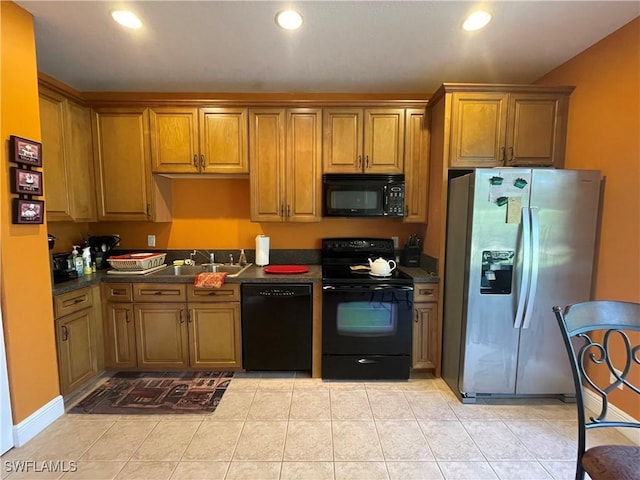 kitchen featuring sink, light tile patterned floors, and black appliances