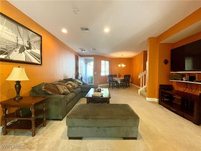 living area with visible vents, a notable chandelier, stairway, carpet, and baseboards