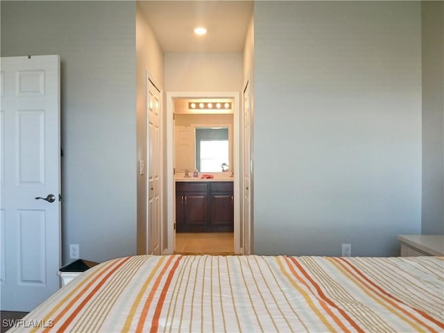 unfurnished bedroom featuring sink, connected bathroom, and light tile patterned flooring