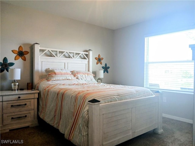 bedroom featuring dark colored carpet and multiple windows