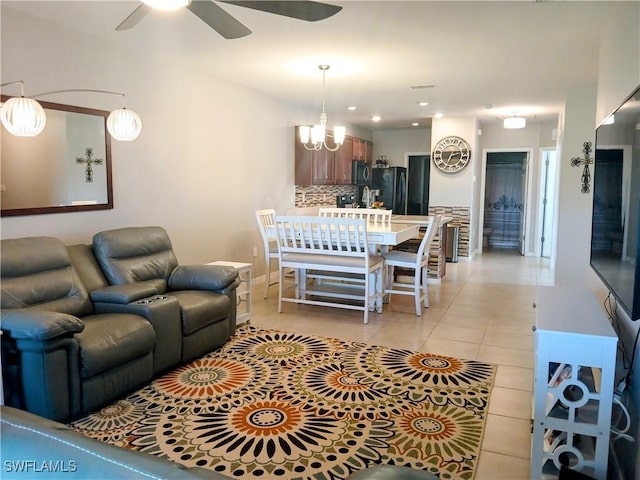 living room featuring light tile patterned floors and ceiling fan with notable chandelier