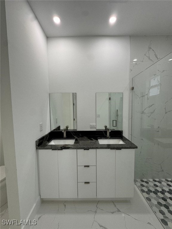 bathroom featuring toilet, vanity, and tiled shower