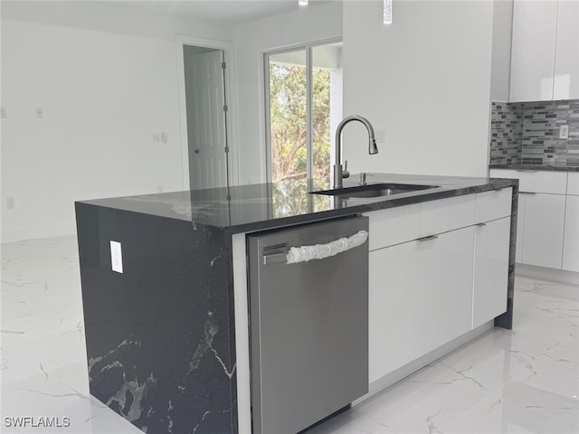 kitchen featuring white cabinets, tasteful backsplash, a kitchen island with sink, sink, and dishwasher