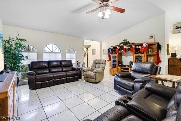 living room with ceiling fan, light tile patterned floors, and vaulted ceiling