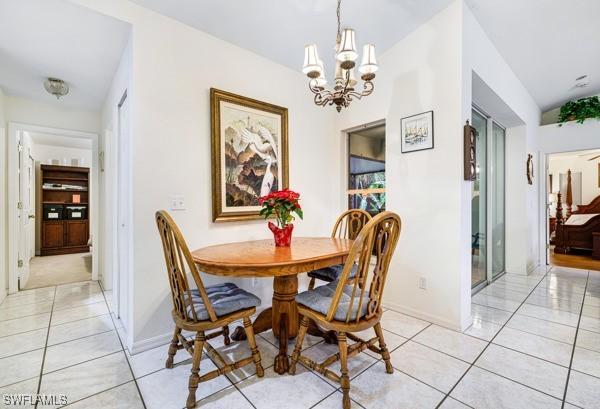 dining room with light tile patterned floors and an inviting chandelier