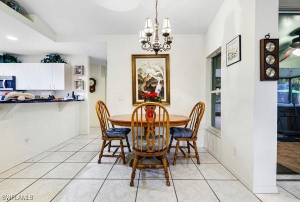 dining room featuring light tile patterned floors and an inviting chandelier