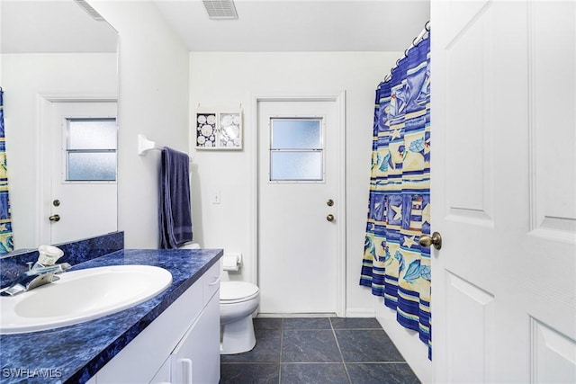 bathroom featuring tile patterned flooring, vanity, and toilet