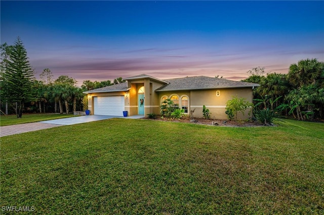 prairie-style home featuring a garage and a lawn