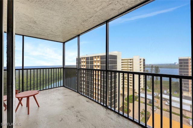 unfurnished sunroom featuring a water view and plenty of natural light