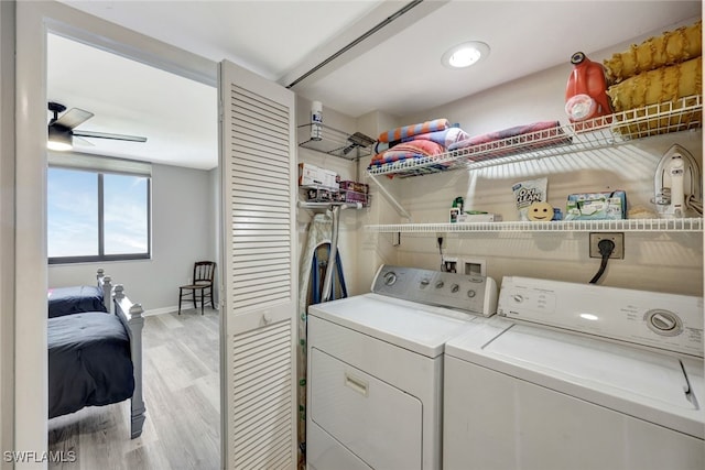 clothes washing area with ceiling fan, washing machine and dryer, and light hardwood / wood-style flooring