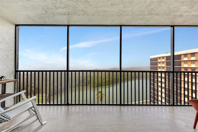 unfurnished sunroom featuring a water view