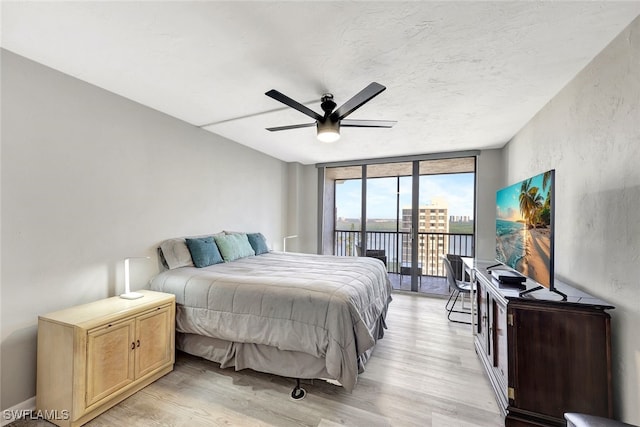 bedroom featuring access to outside, floor to ceiling windows, ceiling fan, and light hardwood / wood-style floors