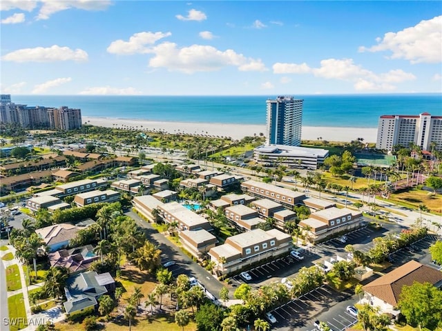 birds eye view of property with a water view and a beach view