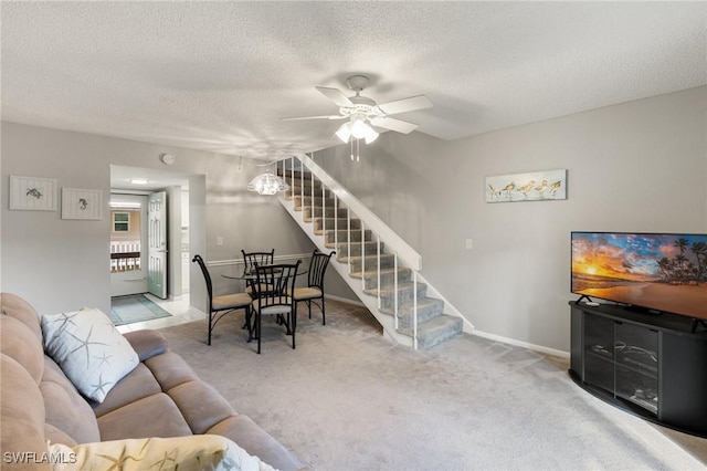 carpeted living room with ceiling fan and a textured ceiling