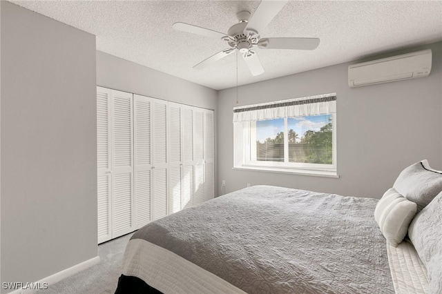 carpeted bedroom featuring a textured ceiling, ceiling fan, a closet, and an AC wall unit