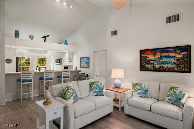 living room with ceiling fan, high vaulted ceiling, and hardwood / wood-style floors