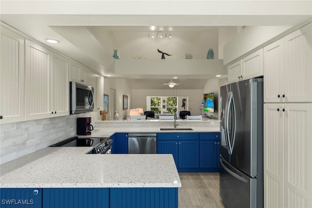 kitchen featuring white cabinetry, backsplash, stainless steel appliances, and kitchen peninsula