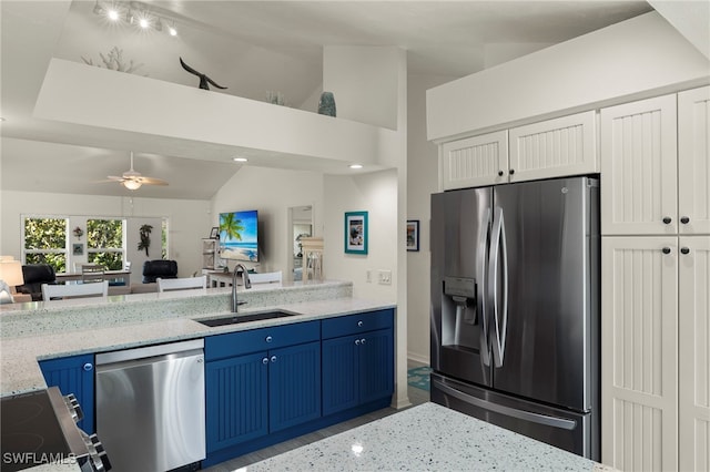 kitchen featuring sink, blue cabinetry, ceiling fan, stainless steel appliances, and light stone counters