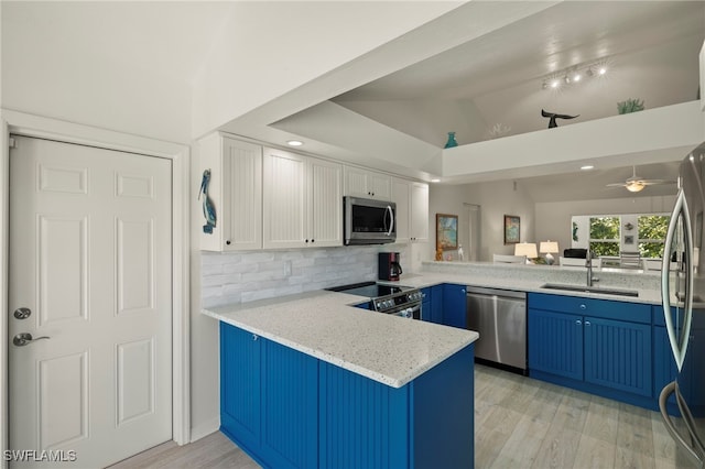 kitchen with white cabinetry, stainless steel appliances, kitchen peninsula, and tasteful backsplash