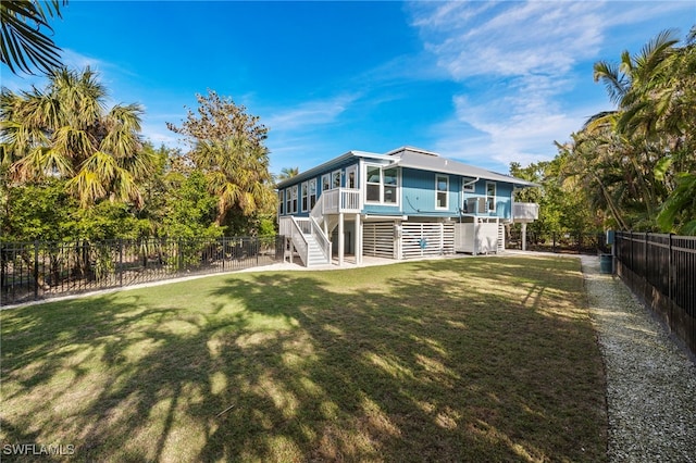 rear view of house with a sunroom and a lawn