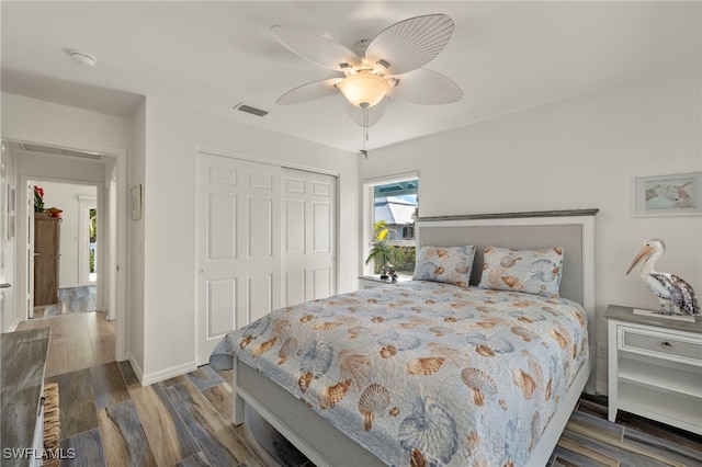 bedroom with dark hardwood / wood-style flooring, a closet, and ceiling fan